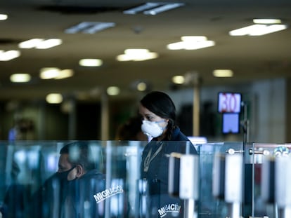 Una empleada con mascarilla en el aeropuerto El Dorado de Bogotá.