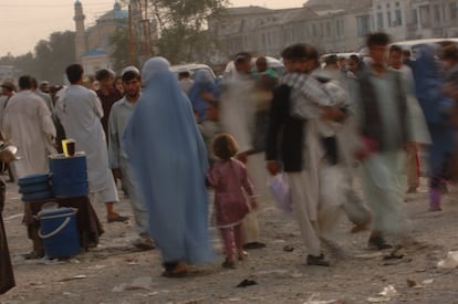Una mujer camina sujetando de la mano a su hija por una calle de Kabul, en 2005.