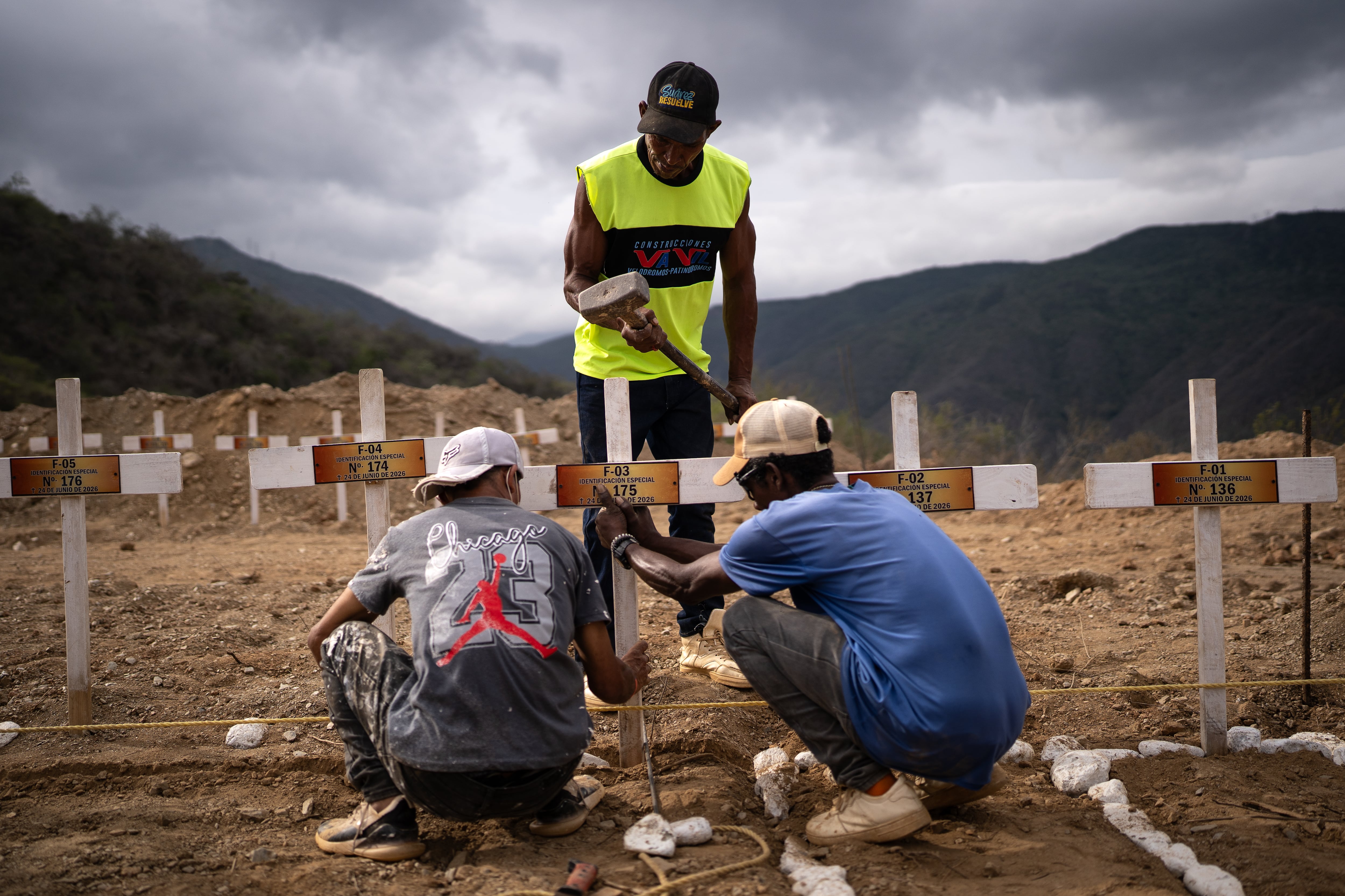 Un grupo de trabajadores instalan las cruces sobre las tumbas de los cuerpos sin identificar, en el cementerio La Esperanza, en La Guaira, el 6 de julio.