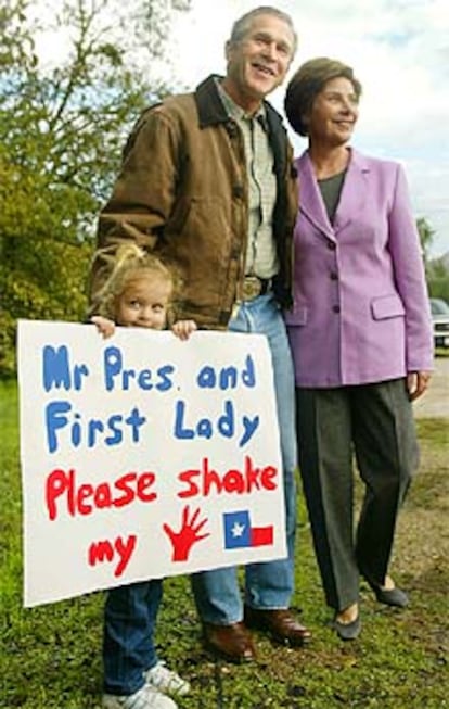 El matrimonio Bush posa junto a una niña de 4 años a la salida del colegio electoral de Crawford.
