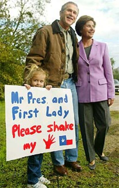 El matrimonio Bush posa junto a una niña de 4 años a la salida del colegio electoral de Crawford.