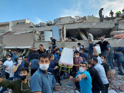 Turquía se ubica en una de las zonas sísmicas más activas del mundo. En la imagen, voluntarios civiles buscan a los atrapados entre los escombros de los edificios derrumbados de Esmirna (Turquía).
