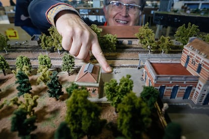 Manuel Garrido enseña las figuras que lo representan a él de niño y a su abuela, en una maqueta de la estación de Linares (Jaén), una de las piezas de ExpoModelTren.