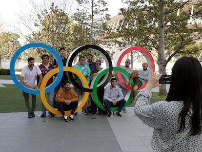 Un grupo de estudiantes uruguayos posan junto a los anillos olímpicos en las afueras del estadio de Tokio (Japón).