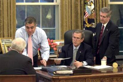 George W. Bush, con el vicepresidente Dick Cheney (de espaldas); el entonces director de la CIA, George Tenet (en mangas de camisa), y el jefe de gabinete del presidente, Andy Card, el 20 de marzo de 2003 en el Despacho Oval.