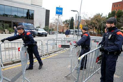 Varios 'mossos' colocan vallas de protección en el hotel donde se alojan los jugadores de ambos equipos.