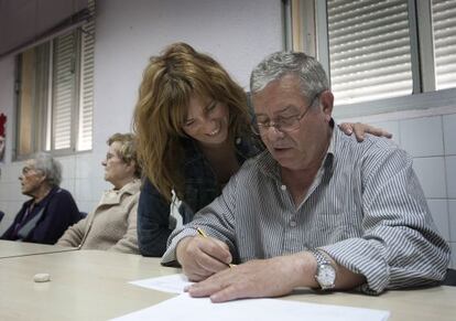 Raquel ayuda a su padre enfermo de alzhéimer, en un taller de la asociación de familiares.