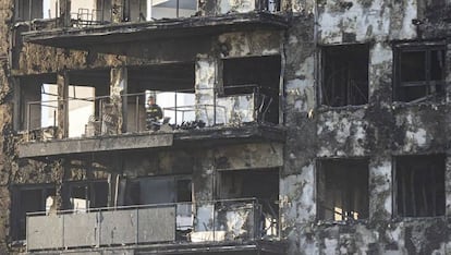 Un bombero inspecciona el interior de uno de los edificios incendiados, este viernes por la mañana.