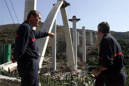 Dos bomberos junto al viaducto que se desplomó en Almuñécar y en el que murieron seis trabajadores.