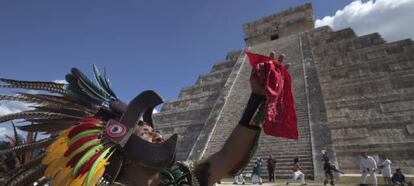 Un hombre vestido de maya, frente a una pirámide en Chichen Itzá.