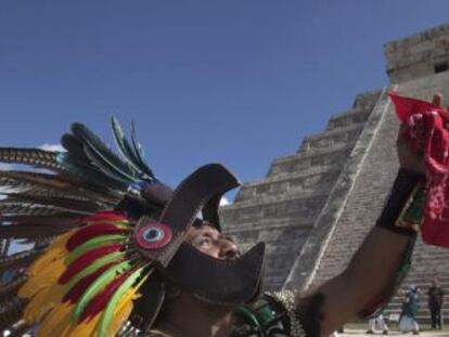 Un hombre vestido de maya, frente a una pirámide en Chichen Itzá.