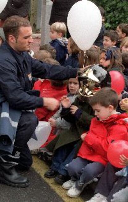 Un bombero del Ayuntamiento entrega ayer globos a varios niños en el hospital de San Rafael.