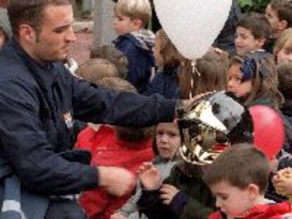Un bombero del Ayuntamiento entrega ayer globos a varios niños en el hospital de San Rafael.
