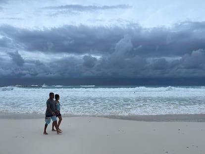 Turistas caminan en una playa de Cancún (Quintana Roo) mientras una tormenta se aproxima, en una fotografía de archivo. 