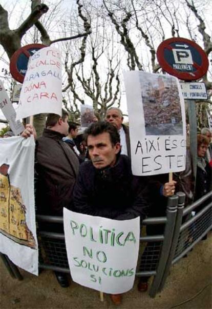 Afectados del Carmel exhiben carteles como los de la imagen frente al Parlamento de Cataluña.