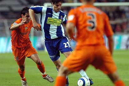 Jarque, del Espanyol, controla el balón entre Fabio Aurelio y Vicente, del Valencia.