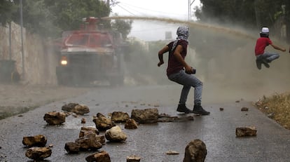 Varios palestinos lanzan piedras a un camión del ejército israelí durante unos disturbios en los asentamientos judíos de Qadomem, cerca de la localidad cisjordana de Nablus.