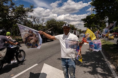 Javier Vélez, vendedor de comida callejera, aprovecha la celebración del Día de la Virgen del Carmen para vender banderas y artículos alusivos a la celebración, en las calles del occidente de Medellín.
