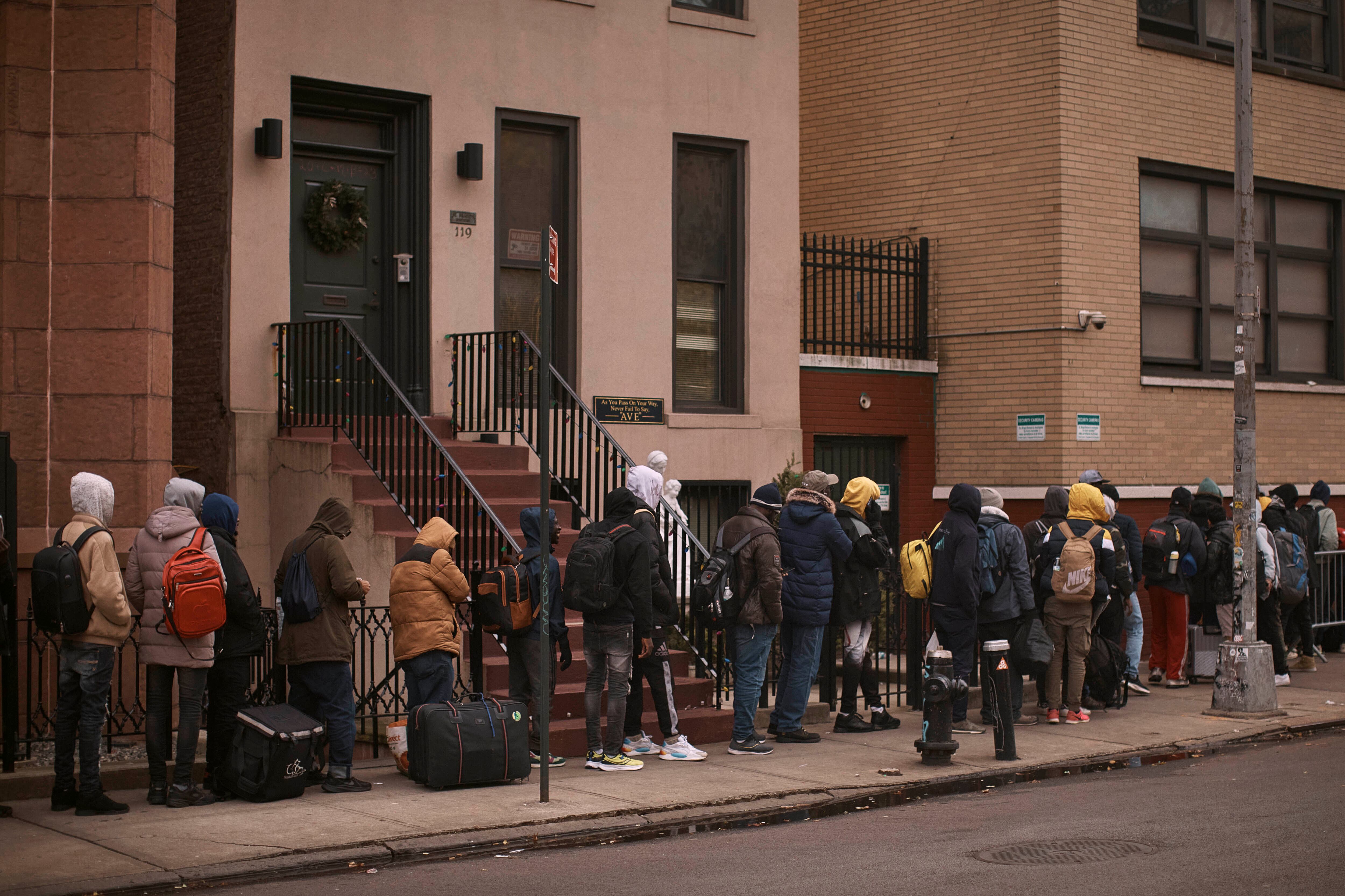 Migrantes esperan en el frío, buscan un refugio fuera de un centro de asistencia migratoria en Nueva York, en diciembre de 2023.