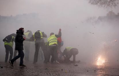 Manifestantes ayudan a una persona herida por un cañón de agua durante la marcha en París.