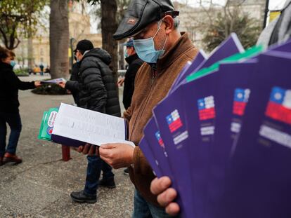 Un hombre lee un ejemplar de la nueva Constitución durante una manifestación a favor del apruebo, el 30 de agosto de 2022 en Santiago.