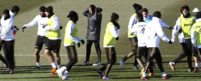 Bien abrigados, los jugadores del Madrid se ejercitan a las órdenes de Mourinho en el entrenamiento de ayer en Valdebebas.