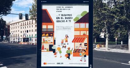 Marquesina informativa con publicidad de Mastercard en una calle de Madrid.