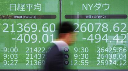 Un viandante pasa junto a un panel de cotizaciones en Tokio.