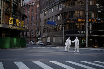 Dos trabajadores con trajes de protección en una calle de Shanghái, el pasado 16 de abril.