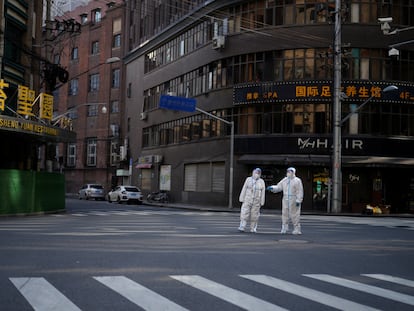 Dos trabajadores con trajes de protección en una calle de Shanghái, el pasado 16 de abril.