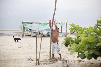 El pescador Darwin prepara un tendedero de ropa en la playa.