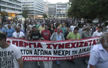 Obreros griegos de la industria del acero Hellenic en huelga sujetan una pancarta en la que se puede leer 'Huelga' durante una protesta en el centro de Atenas, Grecia, el 23 de julio de 2012. EFE/Archivo