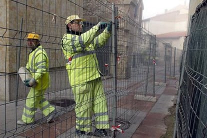 Trabajadores del Ayuntamiento de Salamanca colocan esta mañana vallas para realizar obras frente al Archivo.