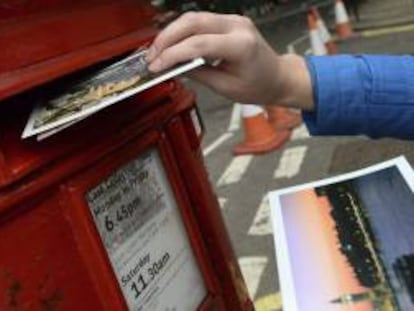 Una persona introduce una carta en un buzón de correos del servicio Royal Mail, en Londres (Reino Unido), hoy. El Gobierno británico anunciará los detalles sobre la privatización del histórico servicio de correos Royal Mail, fundado en 1516.