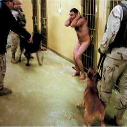 Un prisionero desnudo es acosado con perros en un pasillo de Abu Ghraib.