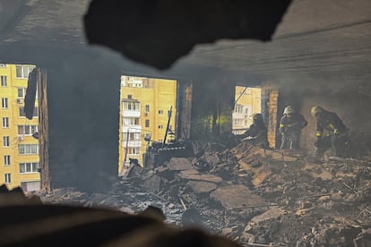 Los bomberos trabajan dentro de un edificio de apartamentos alcanzado por un ataque con drones rusos en Járkov (Ucrania), este sábado.