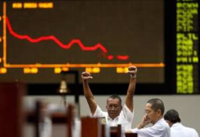 Un corredor de bolsa hace una señal en la Bolsa de Filipinas en el distrito financiero de Makati, Manila, Filipinas. EFE/Archivo