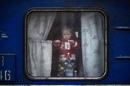 Una niña, en la ventanilla de un tren en la estación central de Kramatorsk, donde muchas familias huyen de la ciudad en la región de Donbás, este lunes. Desde que Rusia anunció su intención de concentrar sus esfuerzos en la "liberación" de Donbás, la tradicional región minera del este de Ucrania, los habitantes viven con el temor de una gran ofensiva militar.