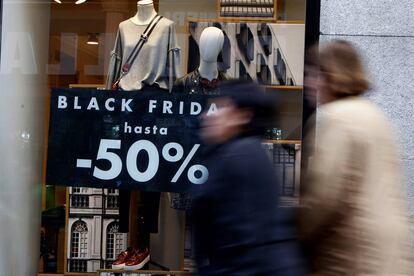 Dos mujeres pasan ante un escaparate con una promoci&oacute;n por el Black Friday.