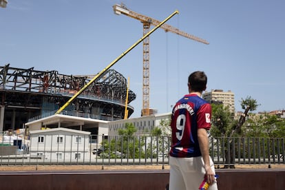 Un aficionado pasa por delante de las obras del Camp Nou