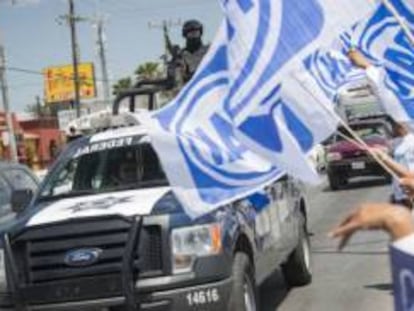 Una patrulla de la Polic&iacute;a Federal junto a simpatizantes del PAN. 