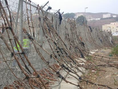 Decenas de escaleras fabricadas con ramas se apilaban sobre la valla fronteriza de Ceuta en octubre de 2005.