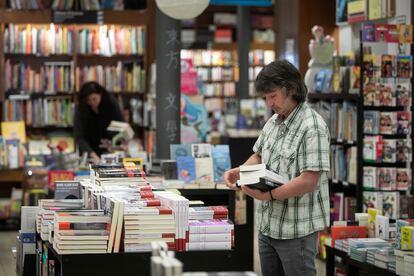 Varias personas escogen libros en una librería de Barcelona.