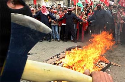 Decenas de palestinos y milicianos enmascarados protestan en Ramala contra la construcción del muro.