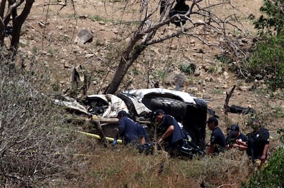 Trabajadores forenses trabajan alrededor de una patrulla atacada con explosivos en Tlajomulco, suburbio de Guadalajara, el 12 de julio.