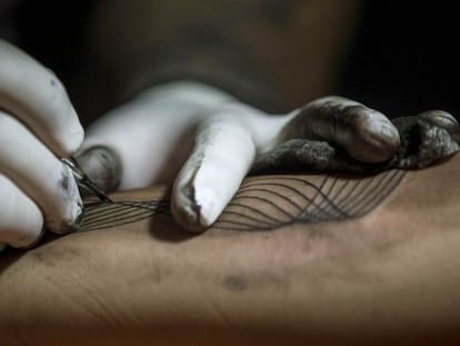 CAR34. CARACAS (VENEZUELA), 02/10/2016.- Detalle de un tatuador haciendo un tatuaje hoy, domingo 2 de octubre del 2016, en Caracas (Venezuela). Un conjunto de profesionales del &quot;arte corporal&quot; ofrecen hacer tatuajes a cambio de donaciones de &uacute;tiles escolares para que ni&ntilde;os de bajos recursos econ&oacute;micos puedan comenzar el venidero a&ntilde;o acad&eacute;mico, esto a trav&eacute;s de la jornada llamada &quot;Tatuajes x &uacute;tiles&quot; que se lleva a cabo en Caracas. EFE/MIGUEL GUTI&Eacute;RREZ