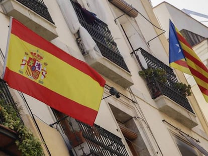 Bandera espa&ntilde;ola y bandera catalana estelada independentista en un edificio de Barcelona.