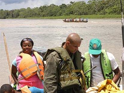 Un agente de la policía nacional de Colombia revisa los equipajes de unos pasajeros que navegan por el Atrato.