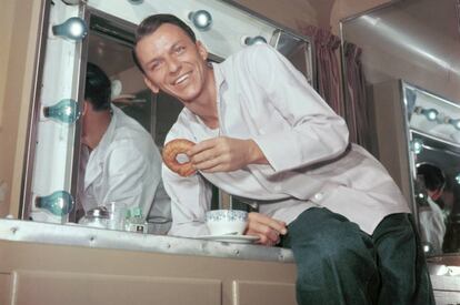 Frank Sinatra disfruta de un donut en su camerino en una imagen tomada en los años cincuenta. A España no llegarían hasta 1962.