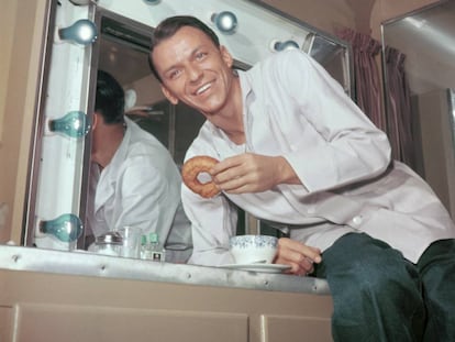Frank Sinatra disfruta de un donut en su camerino en una imagen tomada en los años cincuenta. A España no llegarían hasta 1962.